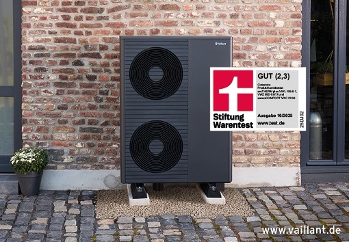 Außengerät einer modernen Wärmepumpe in schwarz mit zwei großen Lüftern, aufgestellt vor einer Backsteinwand im Außenbereich eines Hauses.